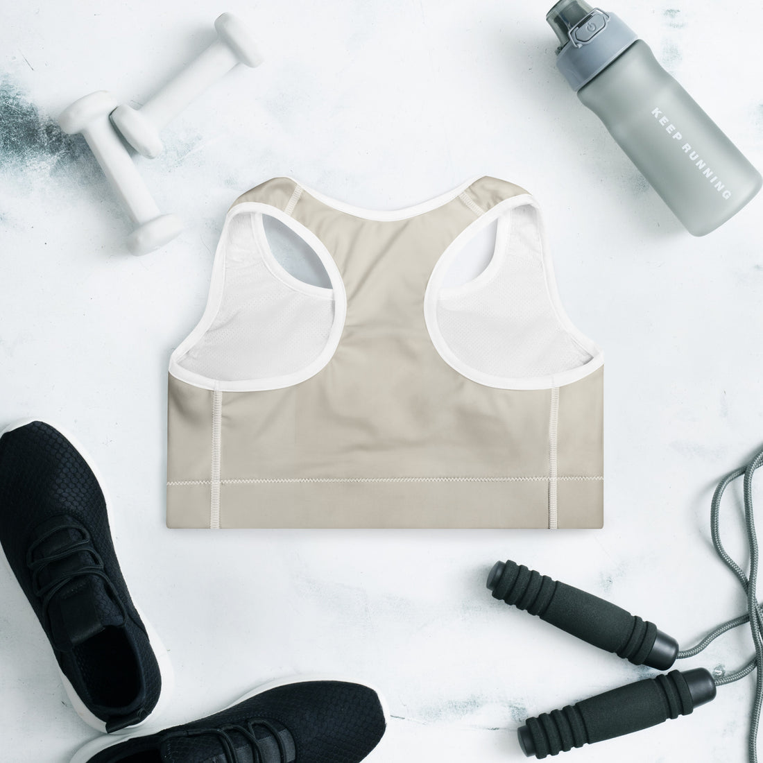 Product mockupBeige Padded Sports Bra Set Do It for the Plot displayed with workout equipment and sneakers.